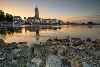 View of buildings at waterfront during sunset