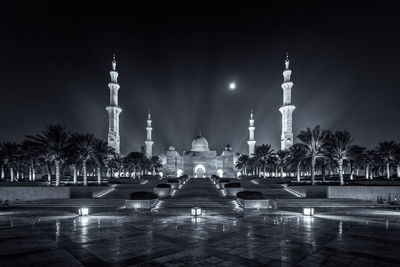 Illuminated grand mosque against sky at night