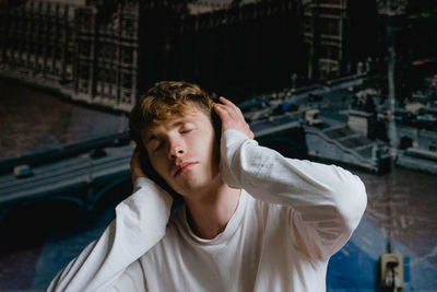 Man with eyes closed listening music at home