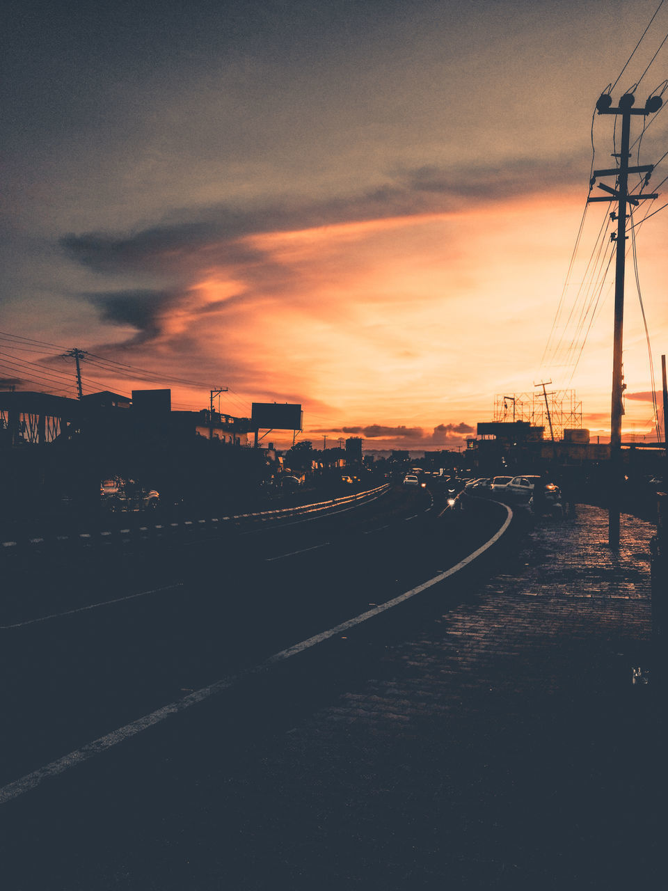 ROAD AGAINST DRAMATIC SKY AT SUNSET