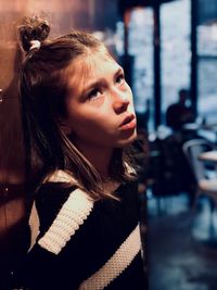 Close-up of thoughtful girl standing in cafe