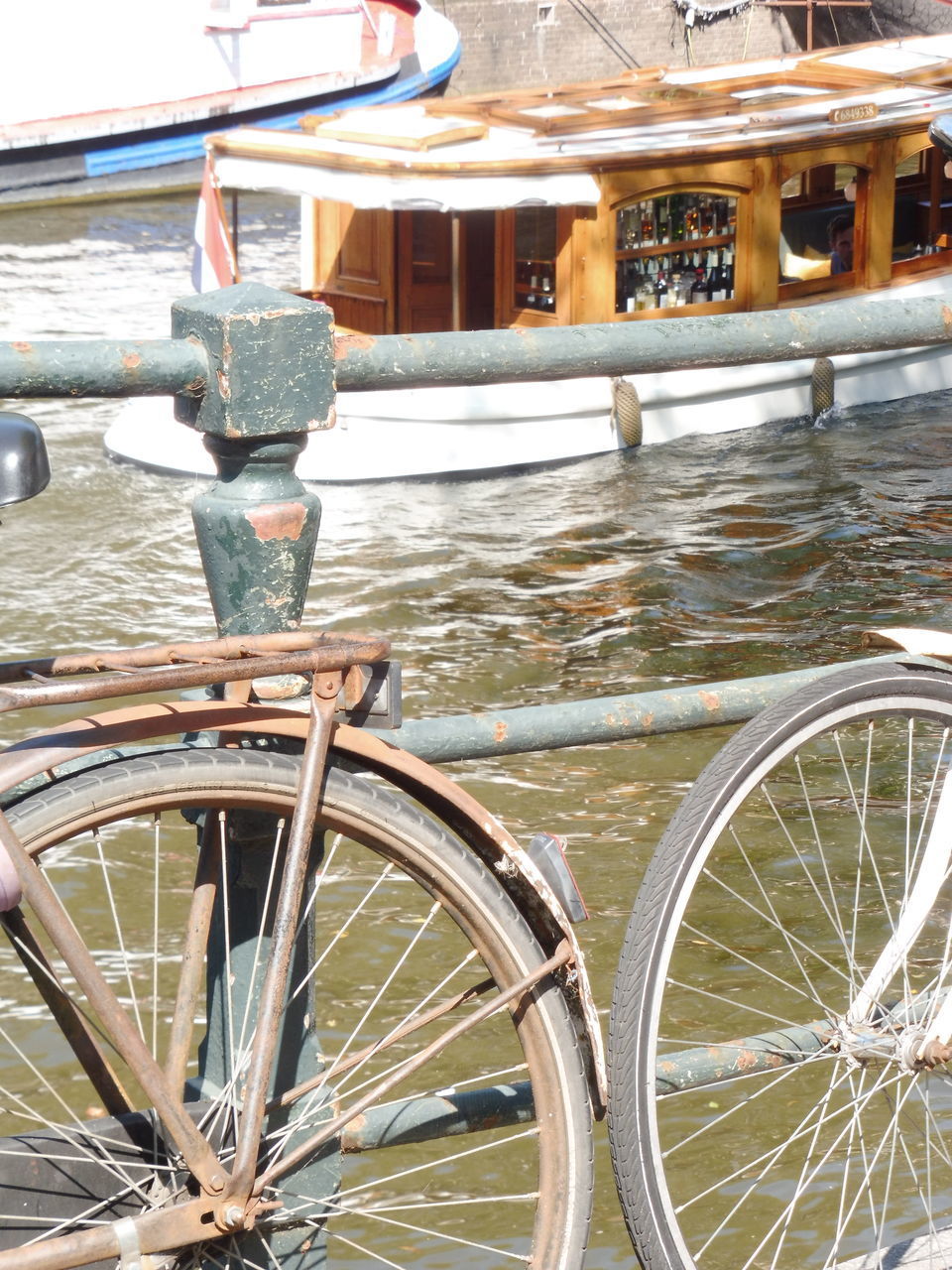 CLOSE-UP OF BICYCLE WHEEL BY WOODEN POST