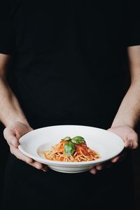 Midsection of person having food in bowl