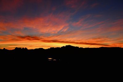 Silhouette landscape against orange sky