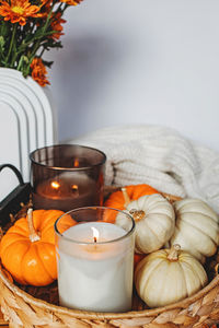 Cozy fall still life composition with decorative pumpkins and candles. autumn home decor.
