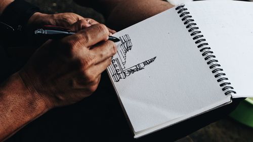 High angle view of man reading book on table