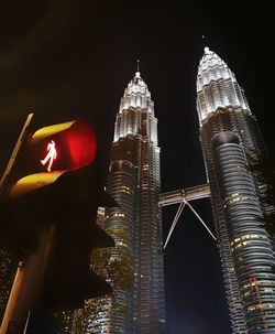 Low angle view of illuminated buildings against sky at night