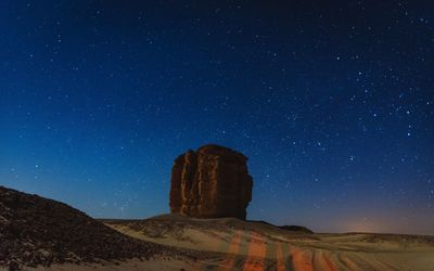 Scenic view of rock formation against sky at night