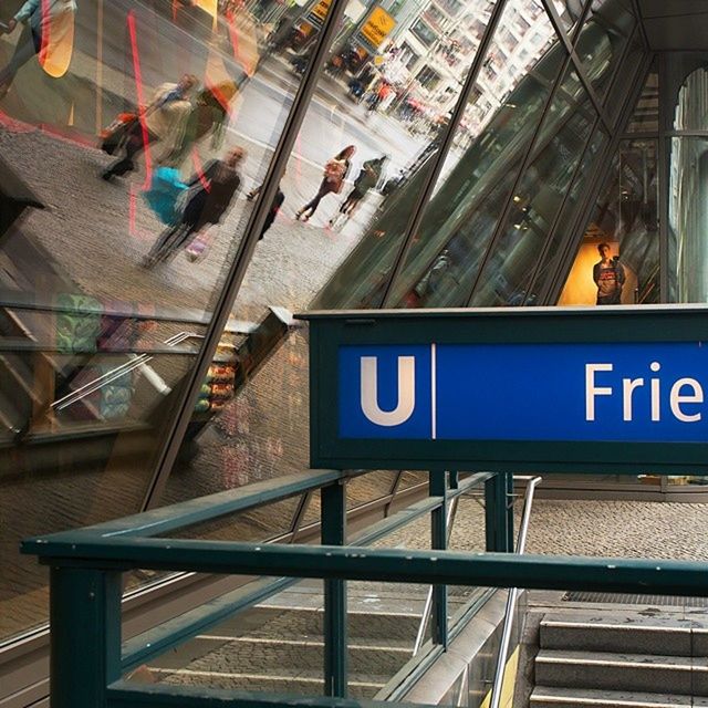 text, indoors, western script, communication, railroad station, public transportation, railroad station platform, subway station, rail transportation, transportation, built structure, information sign, architecture, railroad track, sign, incidental people, non-western script, railing, ceiling, capital letter