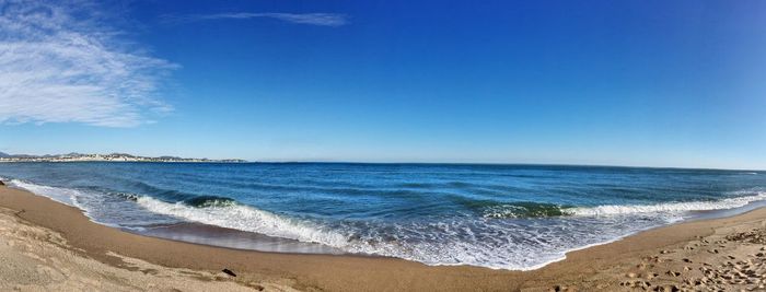 Scenic view of beach against clear blue sky