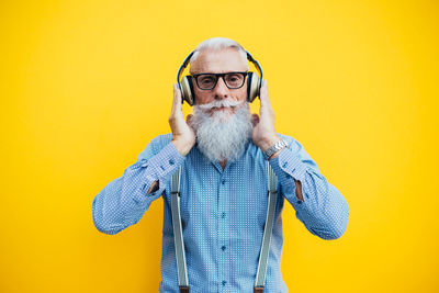 Senior man against yellow background