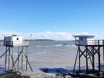 Lifeguard hut on beach against blue sky