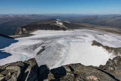 Scenic view of snowcapped mountains against blue sky