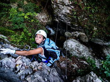 Portrait of smiling young woman rock climbing