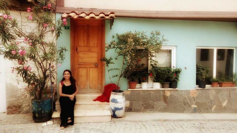 WOMAN STANDING IN FRONT OF HOUSES