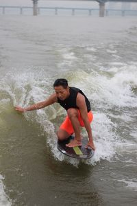 Full length of man splashing water in sea