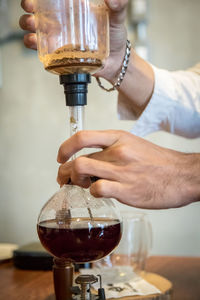 Midsection of man pouring wine in glass