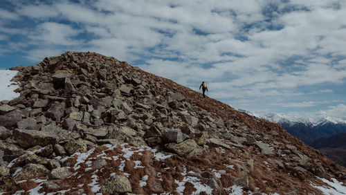 Low angle view of person on rock against sky