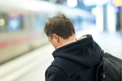 Rear view of man standing in bus