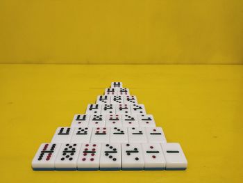 High angle view of piano on table against yellow wall