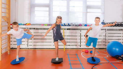 Child doing uni-pedal stance on a balancing disc during physical activity training