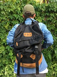 Rear view of backpack man standing by plants