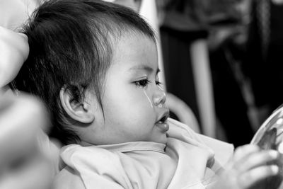 Close-up of cute baby girl looking away