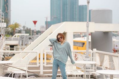 Portrait of smiling young woman standing against yacht