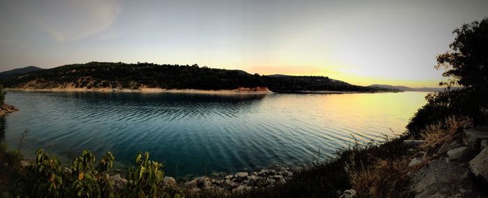 Scenic view of lake against sky at sunset