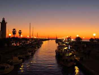 Boats in river at sunset