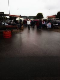 People walking on wet street in city