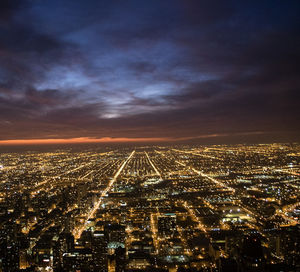 Aerial view of illuminated cityscape against sky at night