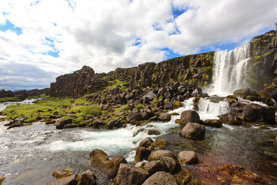 Scenic view of waterfall against sky