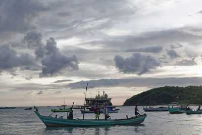 Boats moored in sea against sky