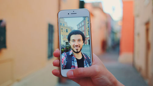 Portrait of smiling woman photographing through mobile phone