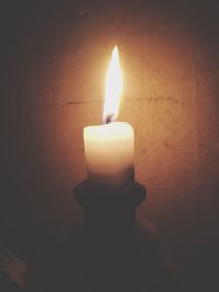 Close-up of lit candle in dark room