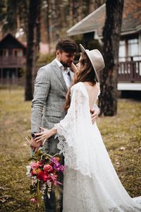 Couple with bouquet embracing in forest