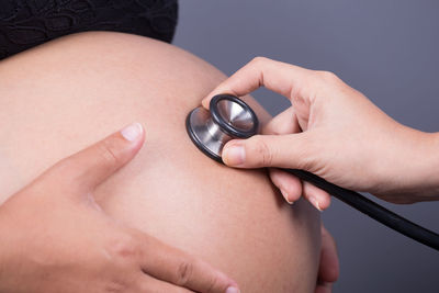Cropped hand of doctor examining pregnant woman