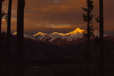 Scenic view of snowcapped mountains against sky during sunset