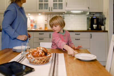 Boy with grandmother in kitchen at home