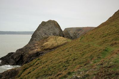 Rock formations by sea against sky