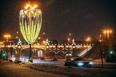 Illuminated light trails on street against sky at night