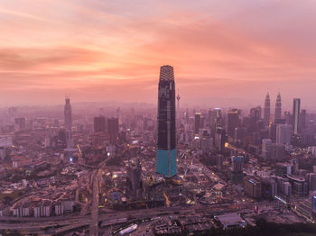 Aerial view of modern buildings in city against sky during sunset