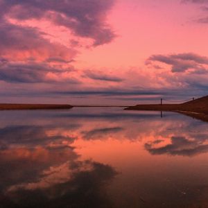 Reflection of clouds in sea at sunset