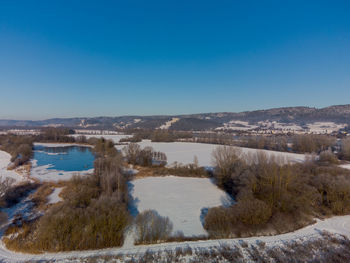 Scenic view of lake against clear blue sky