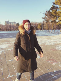 Portrait of teenage girl standing on footpath during winter