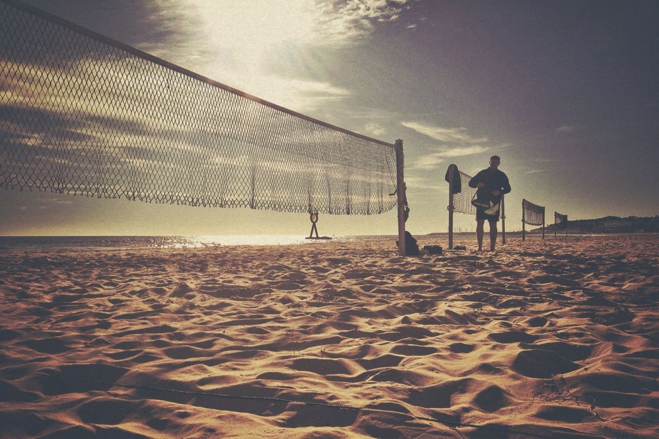 sand, beach, sea, shore, sky, water, men, silhouette, leisure activity, lifestyles, walking, tranquil scene, sunlight, tranquility, nature, unrecognizable person, full length, vacations