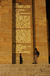 Rear view of people walking in front of building