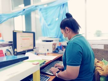 Side view of woman working on table.