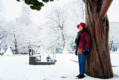 Side view of woman standing in snow
